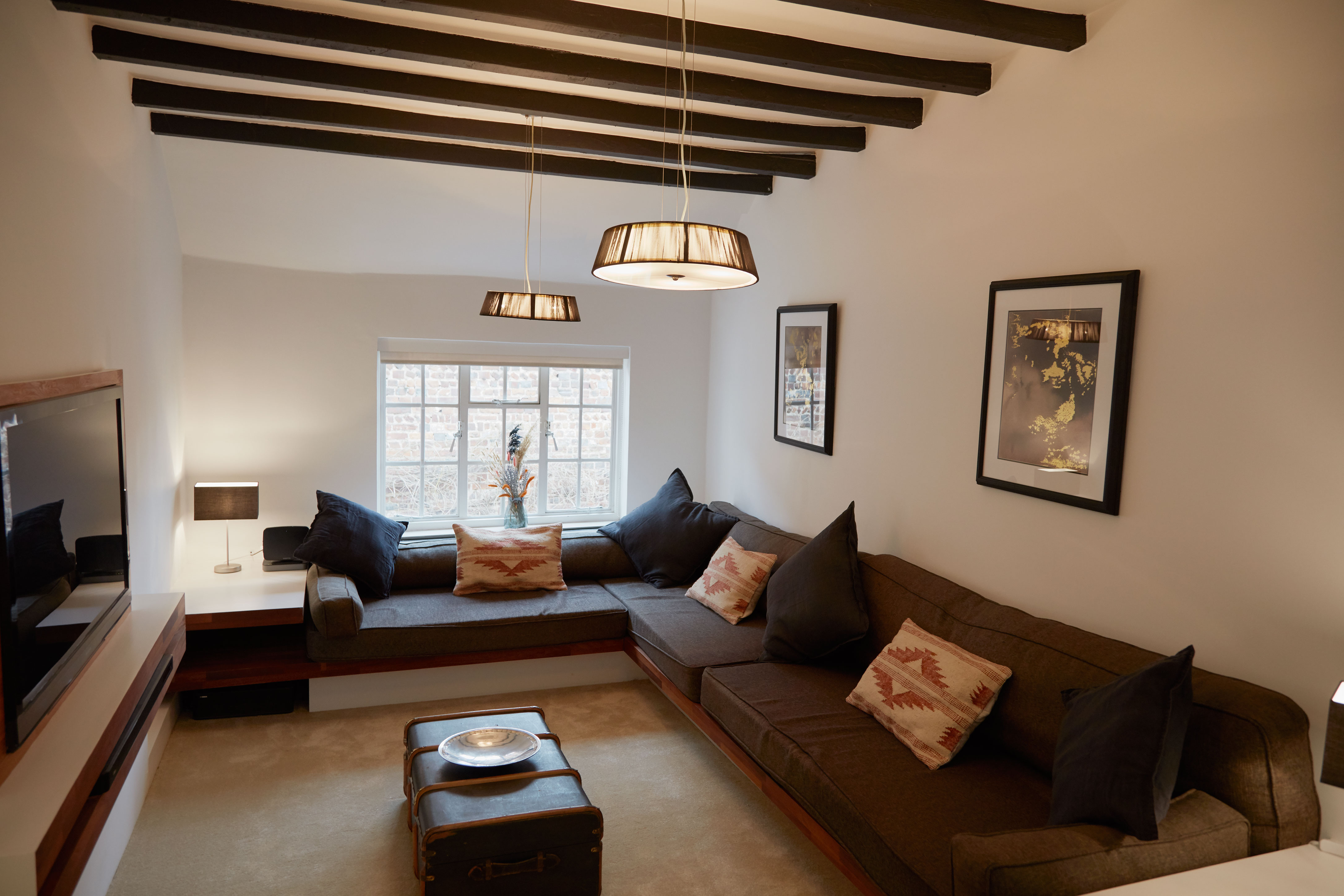 Sitting room with U-shaped sofa and original ceiling beams
