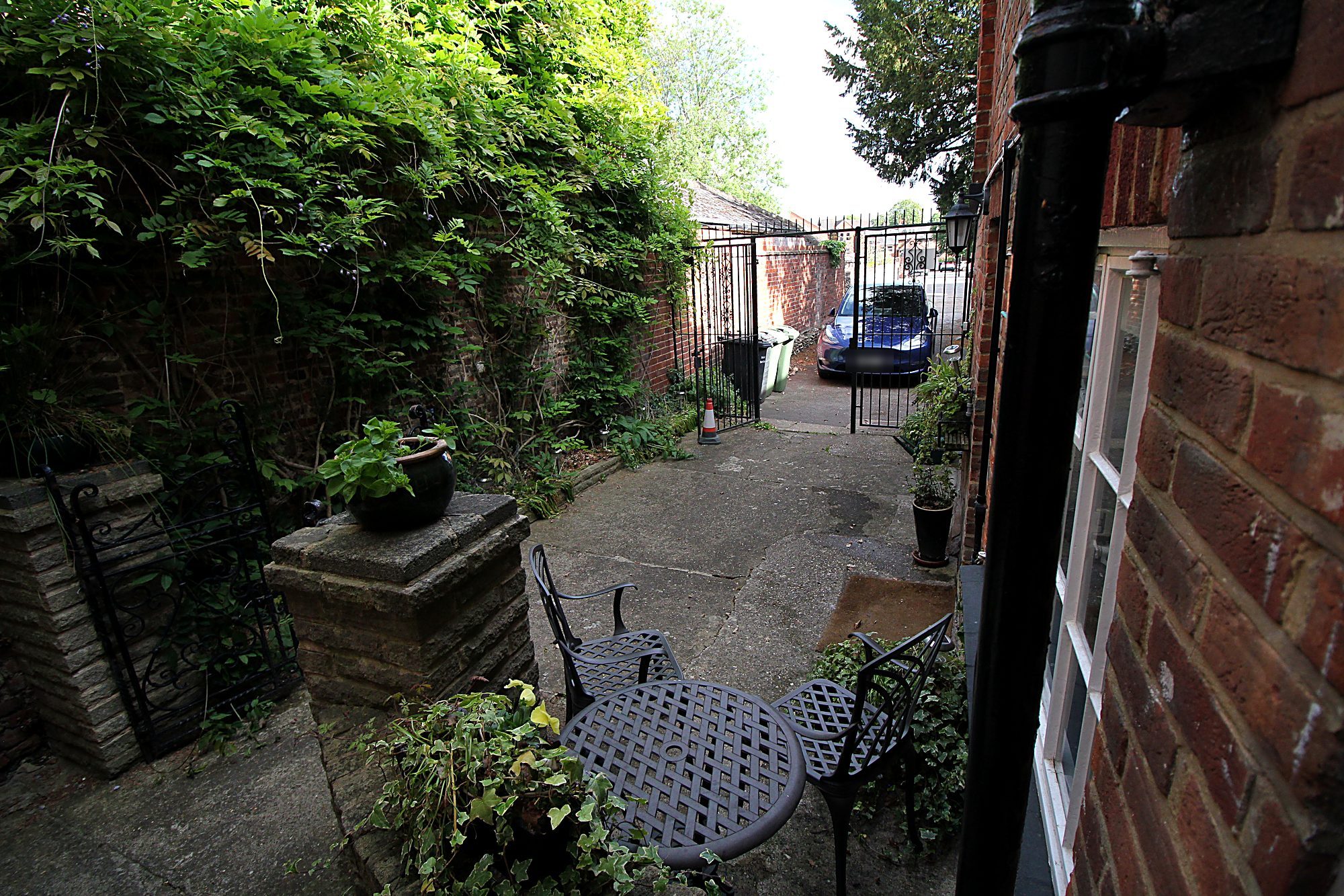 Private courtyard with seating and gated parking