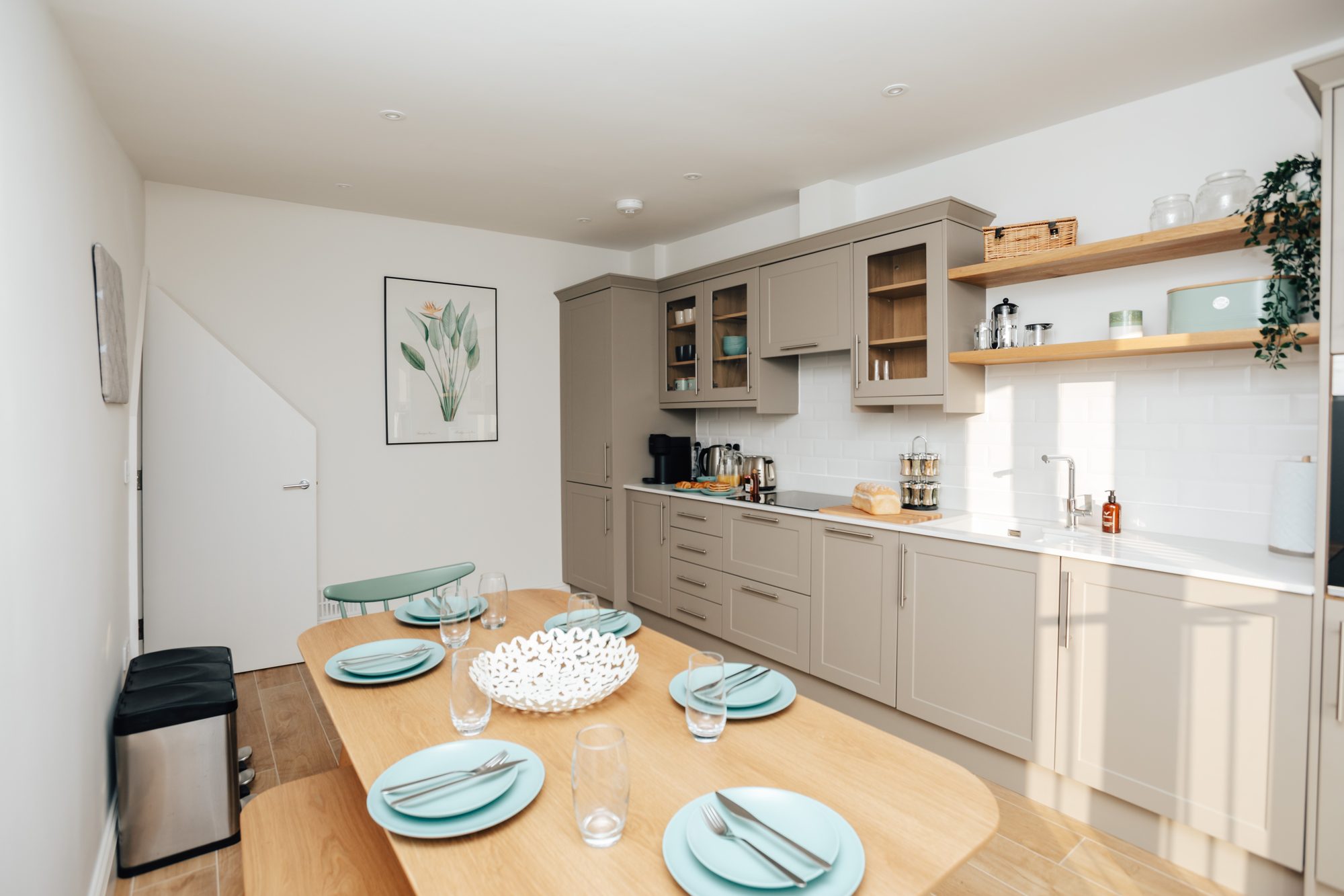 Open-plan kitchen and dining table laid for a meal